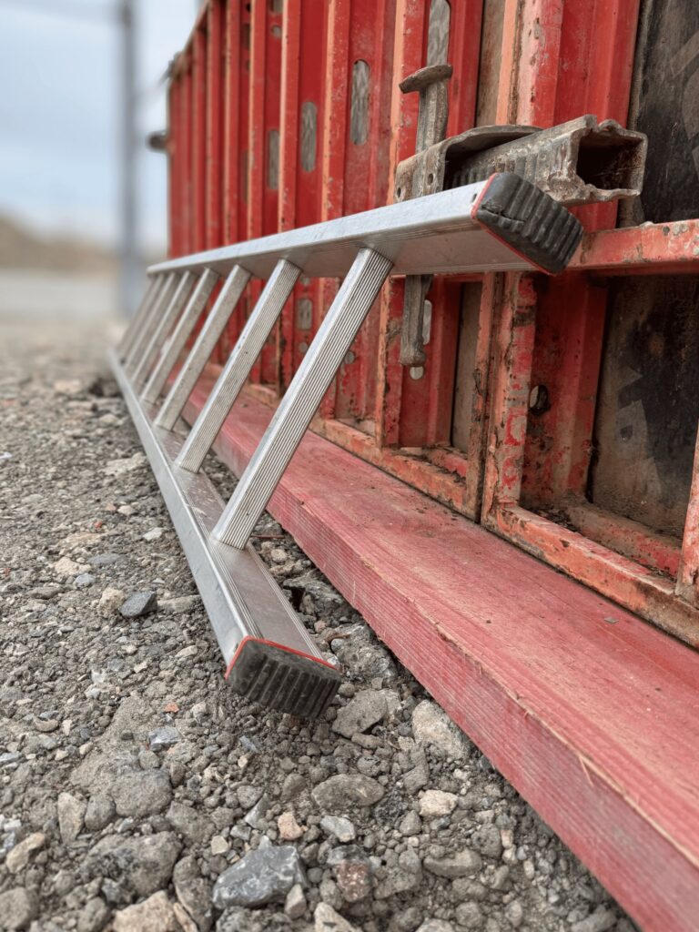 Eine Leiter liegt auf einer Baustelle.