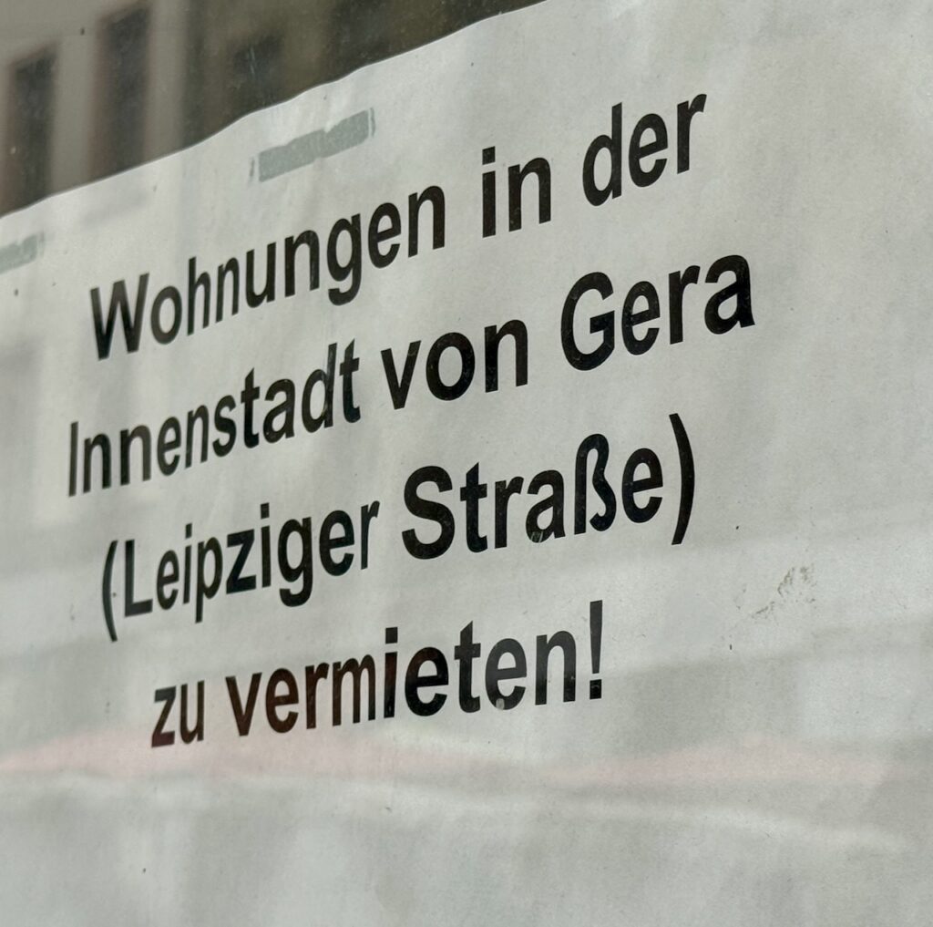 Ein Schild hängt in der Innenstadt Gera. Darauf wird für freie Wohnungen geworben.